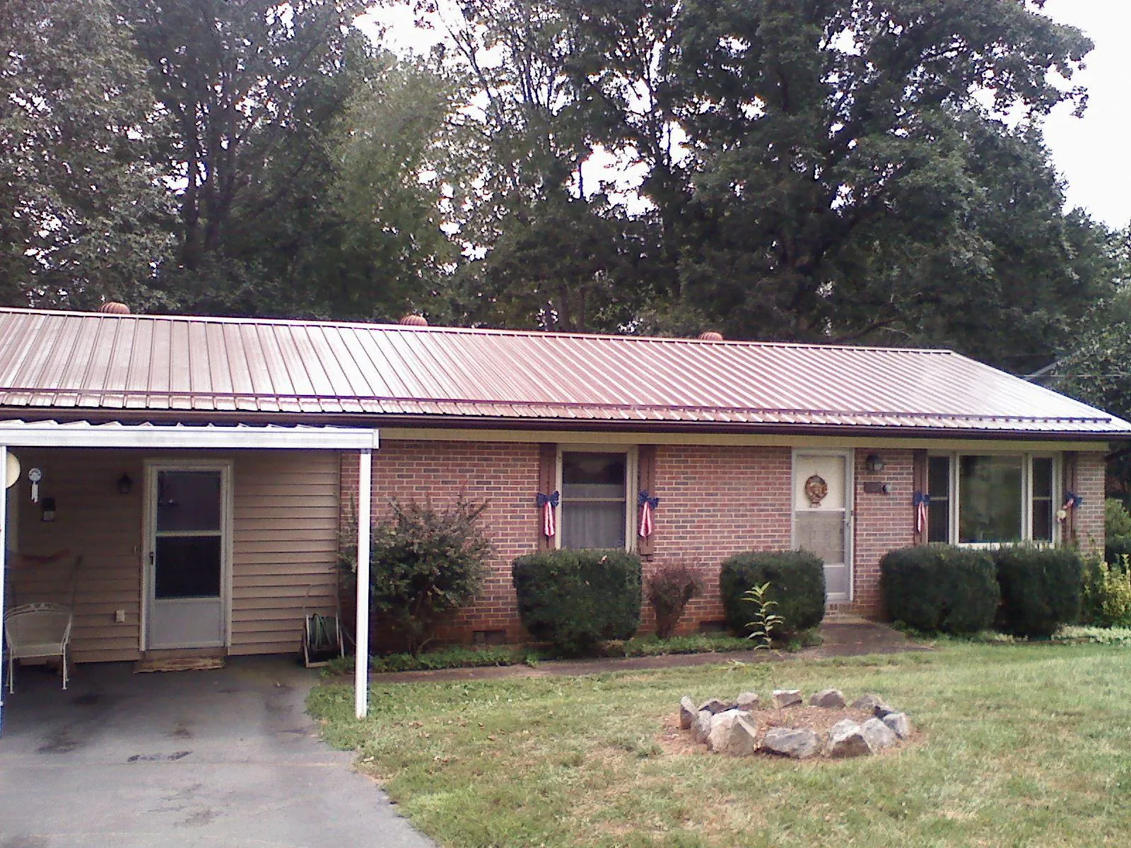 Bronze metal roof and carport on a brick ranch home — Roof Repair work by our crew in Stonewall