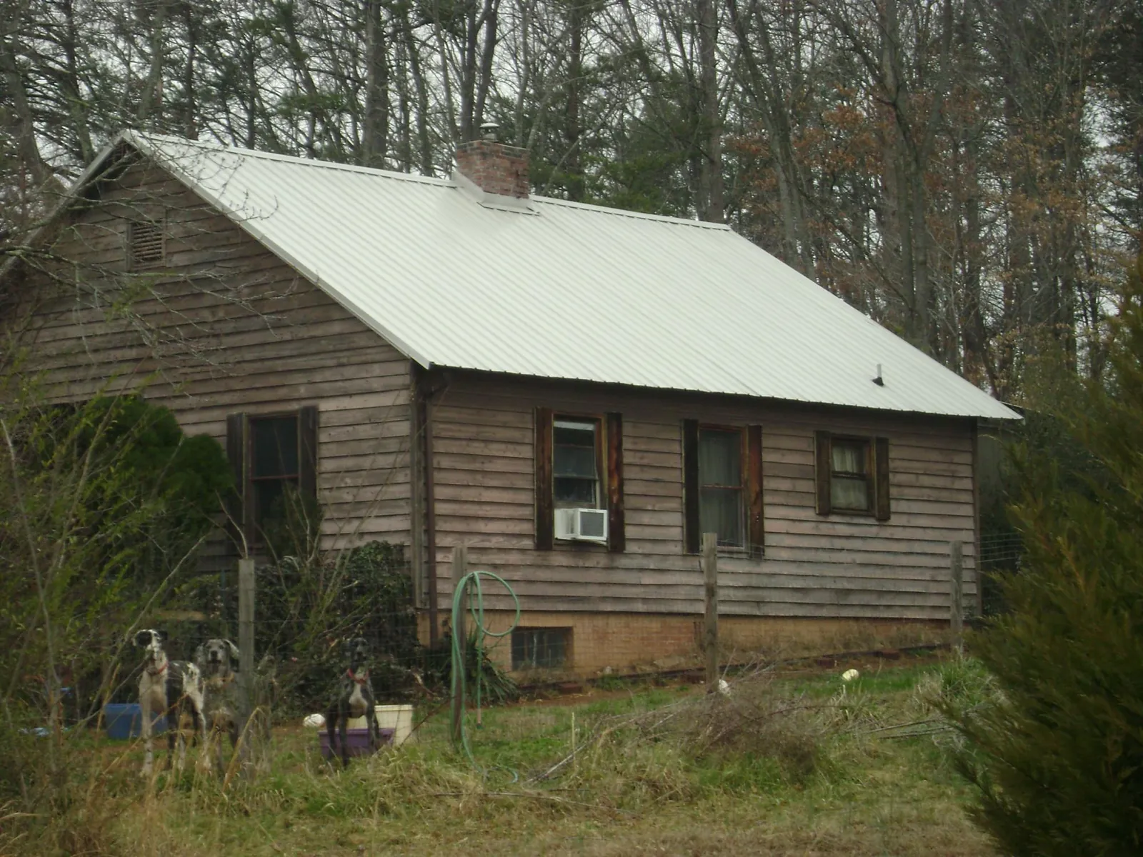 White metal roof on an old wood sided farmhouse, from a Asphalt Shingle Roof Repair job in Stonewall